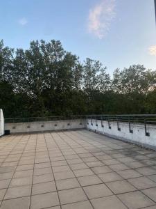 a large patio with a fence and trees at Modern 2 Bed Apartment Next To Station + Parking in Beckenham