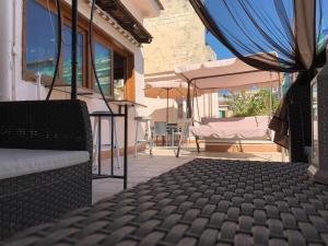 une terrasse avec une table, des chaises et un parasol dans l'établissement Il Poli, à Portici