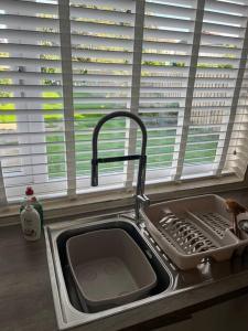 a kitchen sink with a dish drying rack next to a window at Darlington Home Away From Home in Darlington