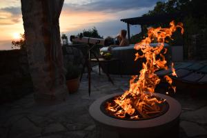 a fire pit in a patio with a man in the background at Amazing STUDIO CASA FERMEGLIA with private jacuzzie and perfect panoramic view in Roč