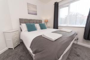 a bedroom with a large white bed and a window at Jesmond Square in Hartlepool