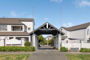 a building with an archway between two houses at Taupo Central Apartment in Taupo