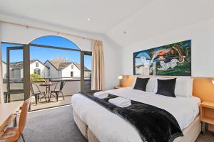a bedroom with a large bed and a balcony at Taupo Central Apartment in Taupo
