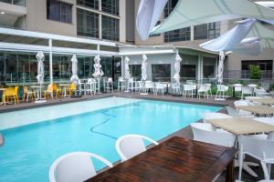 una piscina con mesas y sillas en un hotel en Jordan's Luxe Apartments, en Johannesburgo