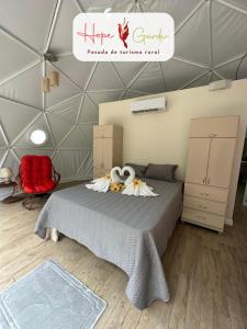 a bedroom with a bed with two stuffed animals on it at Glamping Hope Garden in Sarapiquí