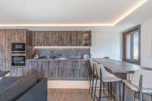 eine Küche mit Holzschränken und einem Holztisch in der Unterkunft Appartement Geneva - Welkeys in Demi-Quartier