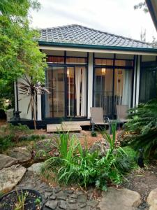 a house with glass doors and a patio at Garden Apartment, self contained, Hunter Valley in Muswellbrook