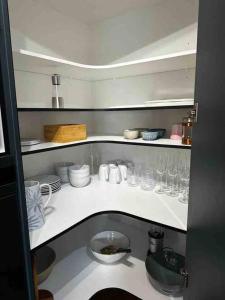 una cocina con vasos y platos en un estante en Woolshed 17 - Self Catering Accommodation, en Havelock North