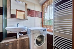 a bathroom with a washing machine and a sink at Apartmány Kateřina in Ricany