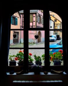 a window view of a street with flowers in pots at Chaud'Vin in Kaysersberg