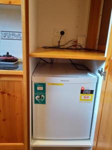 a refrigerator in a kitchen with a shelf on top at Garden Apartment, self contained, Hunter Valley in Muswellbrook