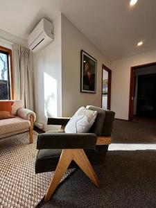 sala de estar con sofá y silla en Woolshed 17 - Self Catering Accommodation, en Havelock North