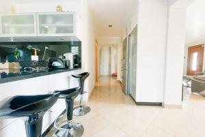 a kitchen with two bar stools in front of a counter at #FW The House of Sunny Gardens in Saint-Ismier