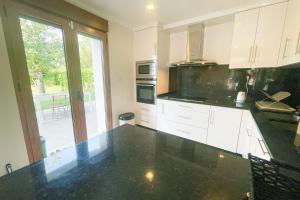 a kitchen with white cabinets and a black counter top at #FW The House of Sunny Gardens in Saint-Ismier +32 photos