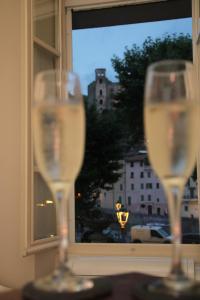 zwei Weingläser auf einem Tisch vor einem Fenster in der Unterkunft Appartamentino - Castle view, no stairs in Dolceacqua