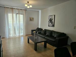 a living room with a black couch and a table at Corfu Glyfada Beach Apartment 59 in Glyfada