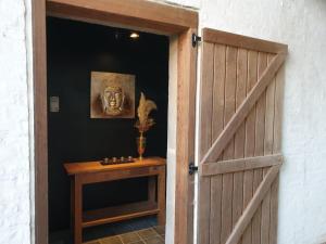 una porta per una stanza con un tavolo e una statua di Het Zonnetje -Vakantiewoning en Bed and Breakfast a Dilsen-Stokkem
