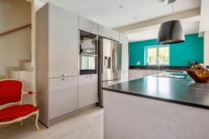 a kitchen with a counter and a red chair at Villa Indigo - Welkeys in Mandelieu-la-Napoule