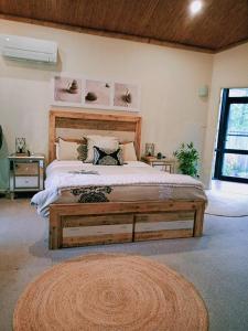 a bedroom with a large bed and a rug at Garden Apartment, self contained, Hunter Valley in Muswellbrook