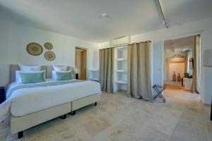 a bedroom with a large white bed with blue pillows at Domaine de Privadière in Garrigues-et-Sainte-Eulalie