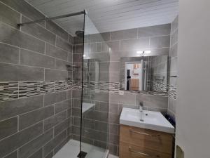 a bathroom with a sink and a glass shower at Appartement 6 personnes - 1 chambre - 4 lits - Netflix & wifi haut débit - Parking couvert in Tignes