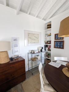 Habitación blanca con mesa de madera y escritorio. en Casas do Horizonte, en Ribeiras
