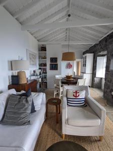 sala de estar con sofá blanco y mesa en Casas do Horizonte, en Ribeiras