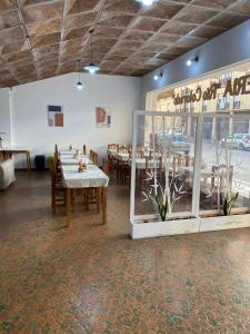 una sala da pranzo con tavoli, sedie e una finestra di Nueva Hostería Rio Colorado Necochea a Necochea