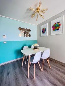 a dining room with a white table and two chairs at Apartamento General Mackenna B&E in Santiago