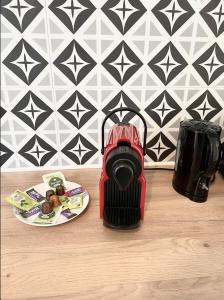 una licuadora roja sentada en una mesa con un plato de comida en Le Golf Sauna - Cosy & SPA - 1 chambre - 2 pers, en Saint-Étienne 2 fotos más