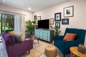 a living room with two purple chairs and a tv at Waterfront Studio Just minutes to Naples Beaches in Naples