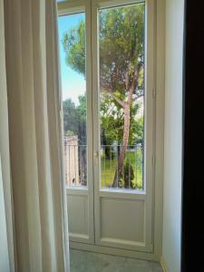 una ventana con vistas a un árbol en Nove Volte B&B, en Catania