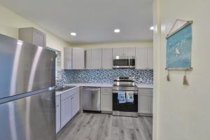 a kitchen with white cabinets and stainless steel appliances at Lovely vacation home 1 block from beach & downtown Gulfport in St Petersburg