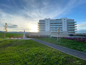 um grande edifício branco com um parque em frente em Moderný apartmán s výhľadom na Vysoké Tatry em Poprad