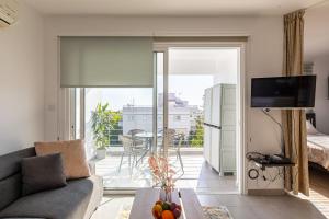 a living room with a couch and a view of a balcony at Cosy Apart at Lykavitos in Nicosia