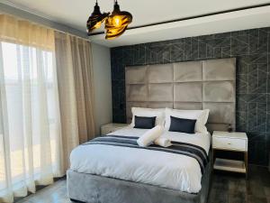 um quarto com uma cama grande e uma grande cabeceira. em Maison De luxe em Thohoyandou