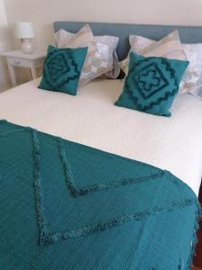ein Bett mit einer blauen Decke und Kissen darauf in der Unterkunft Hotel de Charme Casa Fundevila in Vila Verde