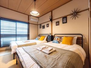a bedroom with two beds and a clock on the wall at Chachamaru Osaka Castle Park - Vacation STAY 15422 in Osaka
