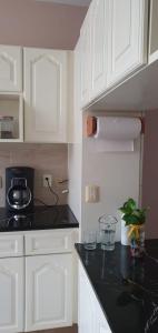 a kitchen with white cabinets and a black counter top at hermosa habitacion en casa residencial in Guadalajara