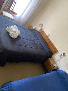 a bed in a room with blue sheets and towels at Nueva Hostería Rio Colorado Necochea in Necochea