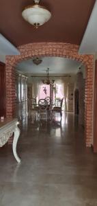een grote kamer met een bakstenen muur en een tafel en stoelen bij hermosa habitacion en casa residencial in Guadalajara