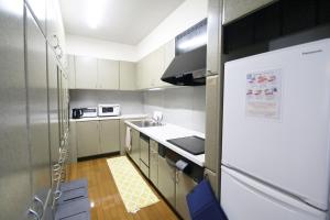 a small kitchen with a white refrigerator in it at cold - Vacation STAY 69755v in Kumamoto