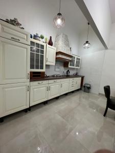 een grote keuken met witte kasten en een tegelvloer bij Apartment Monte in Sarajevo