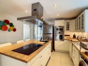 a large kitchen with white cabinets and a stove top oven at Appartement - Duplex 3 CH - 5 pers avec piscine intérieure privative Namur en pleine nature in Floreffe