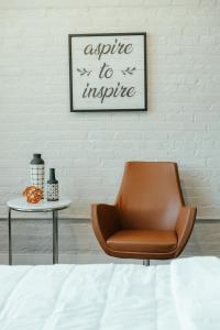 辛辛那提的住宿－REST Suite in Cincinnati M301，白色墙壁旁边的棕色椅子,配有桌子