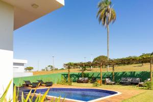 una piscina en un patio con una palmera en Casa alto padrão as margens da represa de Avaré. en Itaí