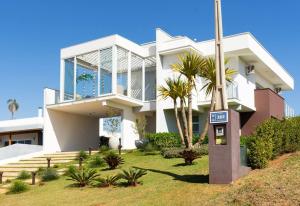 una casa blanca con un cartel delante en Casa alto padrão as margens da represa de Avaré. en Itaí