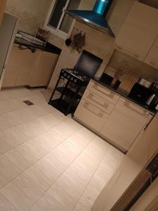 een keuken met een witte tegelvloer bij Kayan apartment1 in Fatḩ Āl Bū Sa‘īd