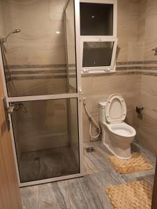 een badkamer met een douche en een toilet met een glazen deur bij Kayan apartment1 in Fatḩ Āl Bū Sa‘īd