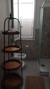 baño con 2 aseos y estanterías en una habitación en Casa Vacanze "O Timpune", en Petrosino